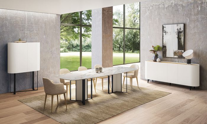 Photo d'une salle à manger avec une collection comprenant une table de repas, une enfilade et un meuble d'appui. Les meubles présentent des finitions en blanc mat laqué, chêne naturel et des piétements en métal noir.