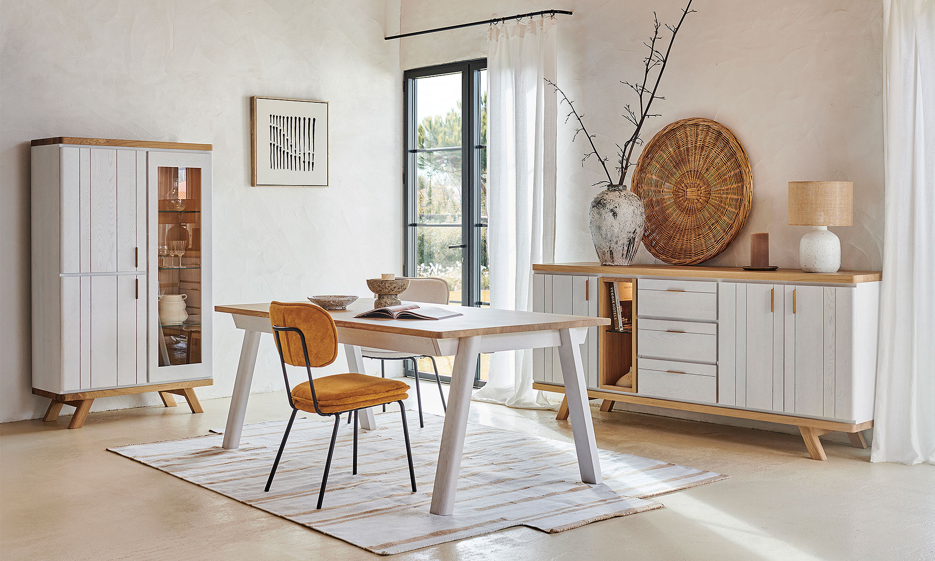 Photo d'ambiance présentant une table, une vitrine et une enfilade décoré d'éléments décoratif en céramique, Avec une finitions bois chêne massif peinte en partie en blanc mat.