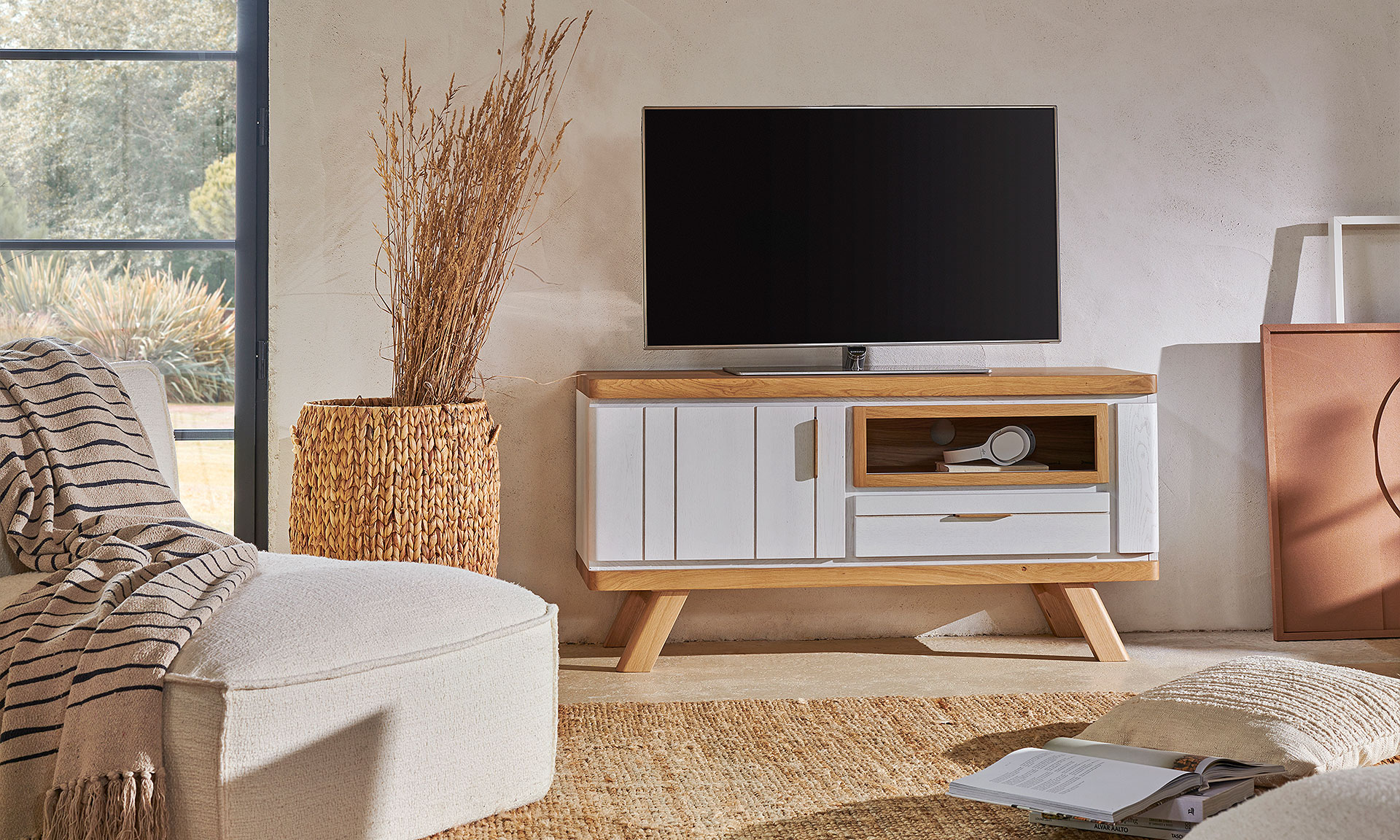 Photo d'ambiance présentant un salon avec un meuble TV. Avec une finitions bois chêne massif peinte en partie en blanc mat.