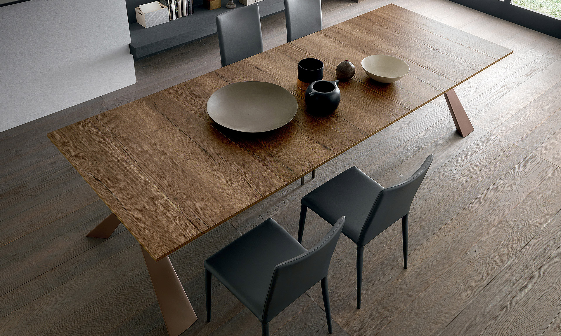 Séjour avec une table en bois chêne massif foncé. Avec des pieds original de part et d'autre.